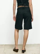 Bermuda negra de vestir con corte a la rodilla.