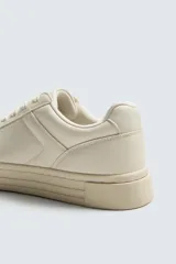 Zapatillas urbanas de cuero sintético color crema, con cordones y suela de goma con plataforma.