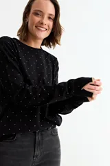 Sweater de tejido de punto fino en color azul melange, con estampado de pequeños corazones negros. Presenta cuello redondo, mangas largas y puños con detalle de borde en contraste.