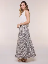 Falda larga de corte evasé con diseño estampado animal print estilo cebra en tonos beige y gris oscuro. Cuenta con tiro alto y pretina elástica fruncida.