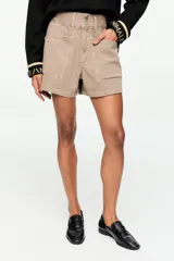 Short de gabardina color marrón, de tiro alto con cierre de dos botones, bolsillos delanteros aplicados con solapa y pasadores para cinturón.