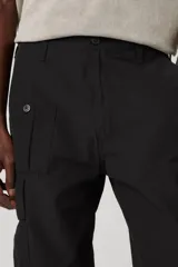 Pantalón cargo negro de corte recto con bolsillos laterales con fuelle y solapa con botón a presión. Tiene bolsillos delanteros y traseros.