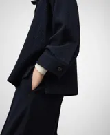 Sobrecamisa de mujer color azul marino con textura sutil de rayas verticales. Presenta un corte amplio (boxy fit), cuello mao (cuello tira) y manga larga con puño. Cierre frontal oculto por solapa.