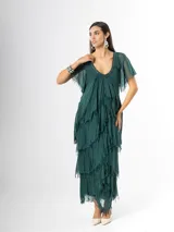 Vestido largo de seda italiana color verde oscuro, con capas escalonadas con flecos, escote en V con detalle de paillettes y mangas cortas fluidas.
