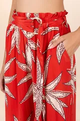 Pantalón palazzo rojo con estampado de hojas color crema y cintura elastizada con lazo.