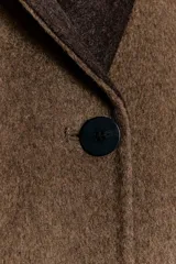 Blazer oversize de Zara Woman Collection confeccionado en mezcla de lana, con cuello sin solapa, manga larga y cierre frontal con botón. Presenta bolsillos delanteros con solapa.