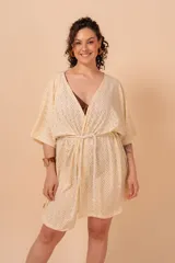 Túnica color crema con calados tipo broderie, escote en V y mangas cortas amplias. Incluye cordón de algodón para ajustar en la cintura.