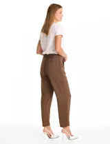 Pantalón de corte relajado con frente liso y cintura elástica en la parte posterior. Presenta una silueta fluida con pierna sutilmente entallada, bolsillos laterales diagonales y bolsillos traseros simulados.