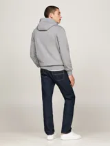 Buzo gris de felpa de algodón con capucha y cordón blanco. Tiene bolsillo tipo canguro, puños y bajo de punto canalé. Logo de Tommy Hilfiger bordado en el pecho.