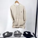 Canguro oversize color crema con capucha y bolsillo delantero tipo canguro.