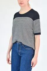 Buzo de punto a rayas horizontales blancas y negras, con mangas cortas y cuello redondo.