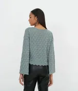 Blusa de punto color verde con textura geométrica, cuello redondo y mangas largas acampanadas con terminación ondulada.