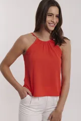 Blusa color coral con cuello halter y tirantes finos.