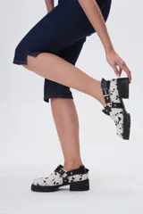 Zapato de cuero negro con hebilla y plataforma con suela track.