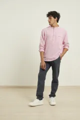 Camisa de lino color rosado, con cuello mao y cierre frontal parcial con botones. Presenta mangas largas y un bolsillo pequeño en el pecho.