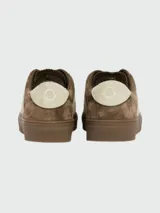 Zapatillas bajas Moncler modelo Moncado2, color crema, con franjas laterales en gamuza color bordó que forman una 'M' y la palabra 'MONCLER' grabada. Tienen cordones grises y suela de goma blanca.