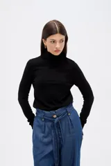 Polera de lyocell color negro, con cuello alto y ajuste al cuerpo, de manga larga.