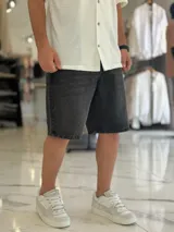 Bermuda de jean de corte oversize, en color negro con efecto gastado.
