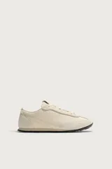 Zapatilla de cordones fabricada en piel con acabado serraje y combinación de piezas de tejido, con suela dentada en contraste de color y pespuntes decorativos.