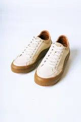 Championes urbanos de gamuza color bordó con suela de goma color caramelo y cordones blancos.