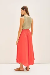 Falda midi de corte fluido con cintura elástica fruncida, confeccionada en tejido satinado de color coral.