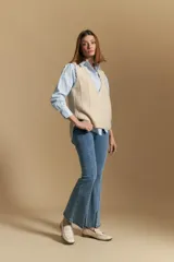 Chaleco tejido color azul, con escote en V, cierre frontal con botones y diseño de líneas verticales en relieve. Presenta terminaciones acanaladas en el ruedo y un borde ondulado en el escote.