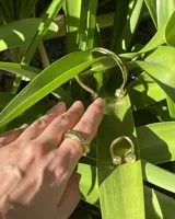 Anillo abierto de diseño minimalista y orgánico, realizado en metal macizo con extremos redondeados de diferentes tamaños.