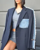Blazer oversize de diseño, confeccionado en tela azul marino con detalles de denim deshilachado en las mangas y un bolsillo de parche de denim con logo bordado en el pecho.