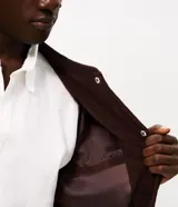 Campera bomber masculina de terciopelo cotelé color beige, con cuello redondo, mangas largas, cierre frontal de botones forrados, bolsillos laterales y terminaciones de elástico en puños y cintura.