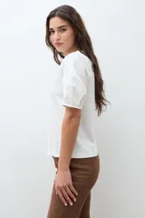 Remera negra de algodón con cuello redondo y mangas cortas abullonadas con detalle de frunces.