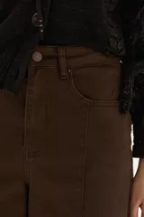 Jean marrón de pierna ancha y tiro alto, con diseño wide leg y costuras frontales decorativas.