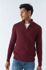 Sweater de tejido de punto acanalado en color negro, con cuello alto y cierre frontal parcial. Cuenta con mangas largas y un pequeño logo bordado en el ruedo.