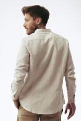 Camisa de corte slim en color beige, confeccionada en tejido de lino, con cuello mao y cierre frontal de botones.