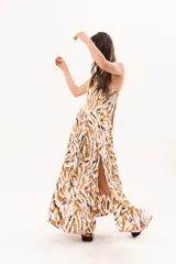Vestido largo de tela sedosa con estampado abstracto en tonos camel, blanco y negro, escote en V pronunciado, tirantes anchos y tajos laterales.