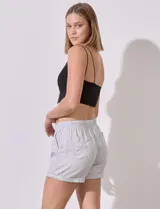 Short blanco de tencel marca Workshop, con pretina elastizada, fruncida y con lazo de ajuste. Delantera y trasera con bolsillos aplicados.