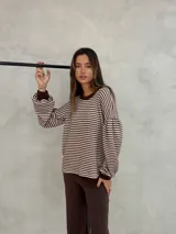 Sweater de tejido de punto con diseño de rayas horizontales en color marrón y blanco. Presenta cuello redondo, mangas largas abullonadas con puños ajustados en color marrón sólido y un corte holgado.