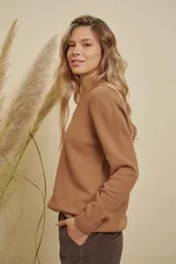 Buzo de punto color marrón, con cuello redondo y mangas largas, de corte holgado.