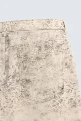 Pantalón de corte baggy fit confeccionado en tejido de algodón con efecto lavado y estampado abstracto en tonos beige y gris. Presenta diseño de cinco bolsillos, cierre frontal con cremallera y botón.
