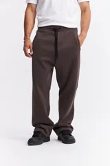Pantalón de algodón de corte recto y estilo relajado, color beige. Cuenta con cintura elástica con cordón de ajuste, bolsillos laterales y logo de la marca estampado discretamente en el frente.