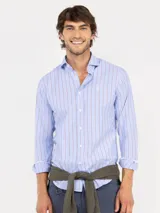 Camisa de manga larga confeccionada en algodón, con diseño de rayas verticales en tonos celeste y bordó. Presenta cuello italiano, cierre frontal con botones y logo bordado en el pecho.