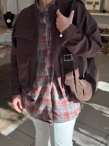 Cartera tipo hobo de cuero color chocolate, con diseño de media luna, correa ajustable con hebilla metálica y cierre superior.