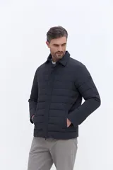 Campera puffer negra de líneas horizontales, con cuello camisero y cierre frontal oculto. Presenta un diseño minimalista con bolsillos laterales funcionales.