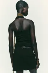 Falda pantalón negra de tiro alto con diseño cruzado y pliegues drapeados en el frente.