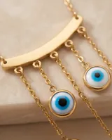 Collar de acero con baño de oro, compuesto por una cadena fina y un dije central en forma de arco del que cuelgan cinco dijes pequeños con diseño de ojo turco.