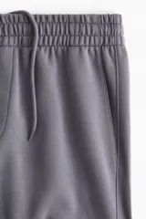 Pantalón deportivo de corte regular, confeccionado en tejido de felpa interlock con interior cepillado. Presenta cintura elástica con cordón de ajuste oculto, bolsillos laterales al bies, un bolsillo trasero insertado y puños acanalados en los tobillos.