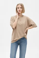 Remera de algodón blanca, de manga corta, cuello redondo y diseño holgado con estampa en el pecho.