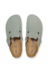 Zueco Birkenstock modelo Boston, confeccionado en gamuza color verde salvia. Presenta una tira ajustable con hebilla metálica al tono, plantilla anatómica de corcho y suela de goma negra.
