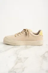 Zapatilla urbana de cuero color beige con detalles en rosa y amarillo.