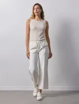 Pantalón jogger color crema, de corte ancho, con pretina elastizada y lazo de ajuste.