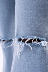 Pantalón de jean estilo wide leg color azul claro, con diseño de tiro alto, corte holgado y roturas desgastadas en ambas rodillas.